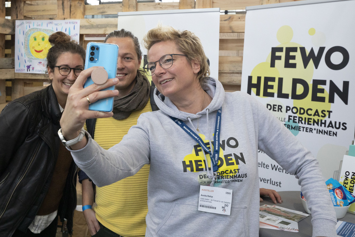 3 Frauen machen ein Selfie vor dem Messestand von FEWO Helden.